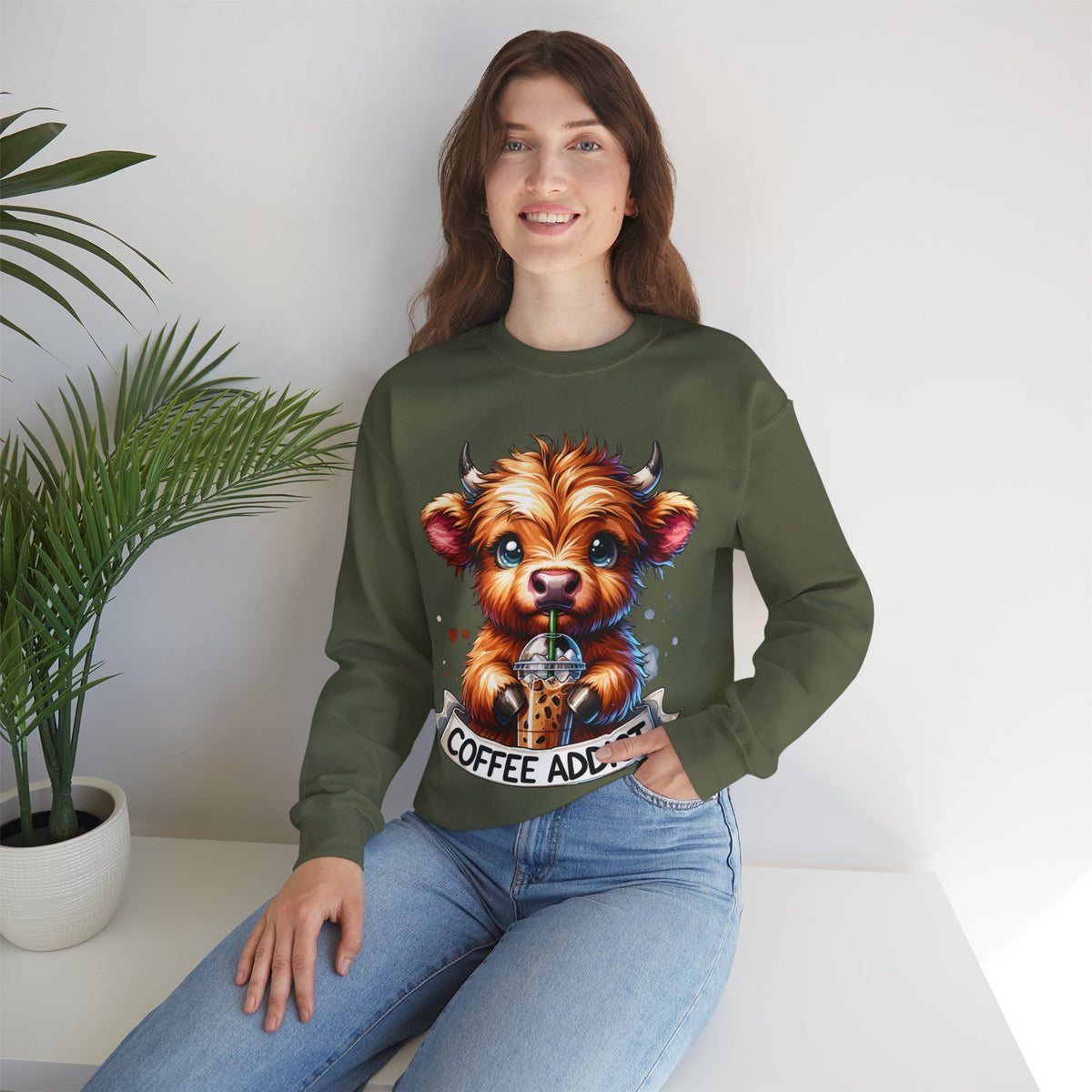 Coffee Addict Highland Cow Drinking Iced Coffee – Gildan Heavy Blend | Trendy Women’s Soft Sweatshirt. Direct to Garment. Printed & Shipped in the USA. Unisex Sizes.