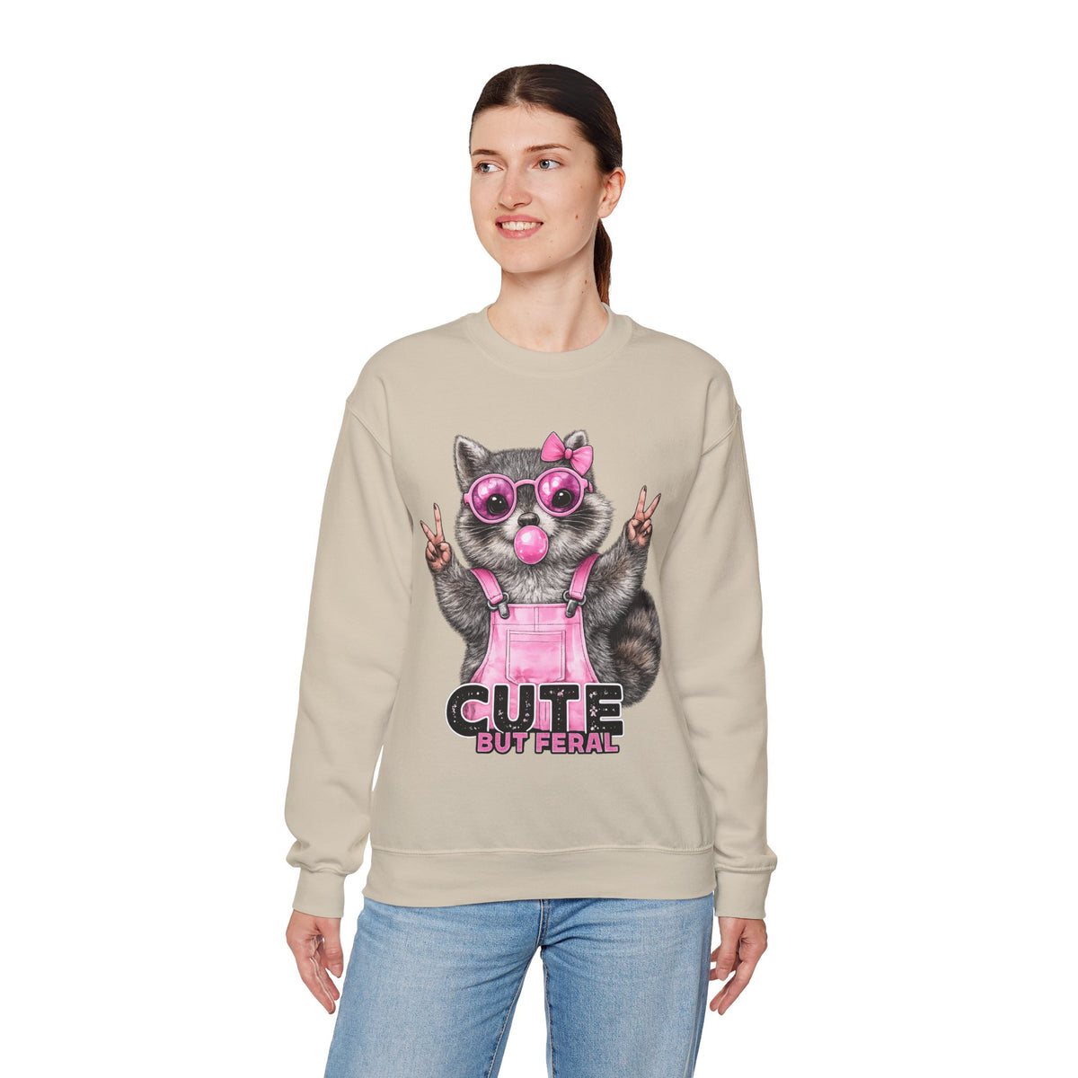 Cute But Feral, Raccoon in Pink Bibs – Gildan Heavy Blend | Trendy Women’s Soft Sweatshirt. Direct to Garment. Printed & Shipped in the USA. Unisex Sizes.