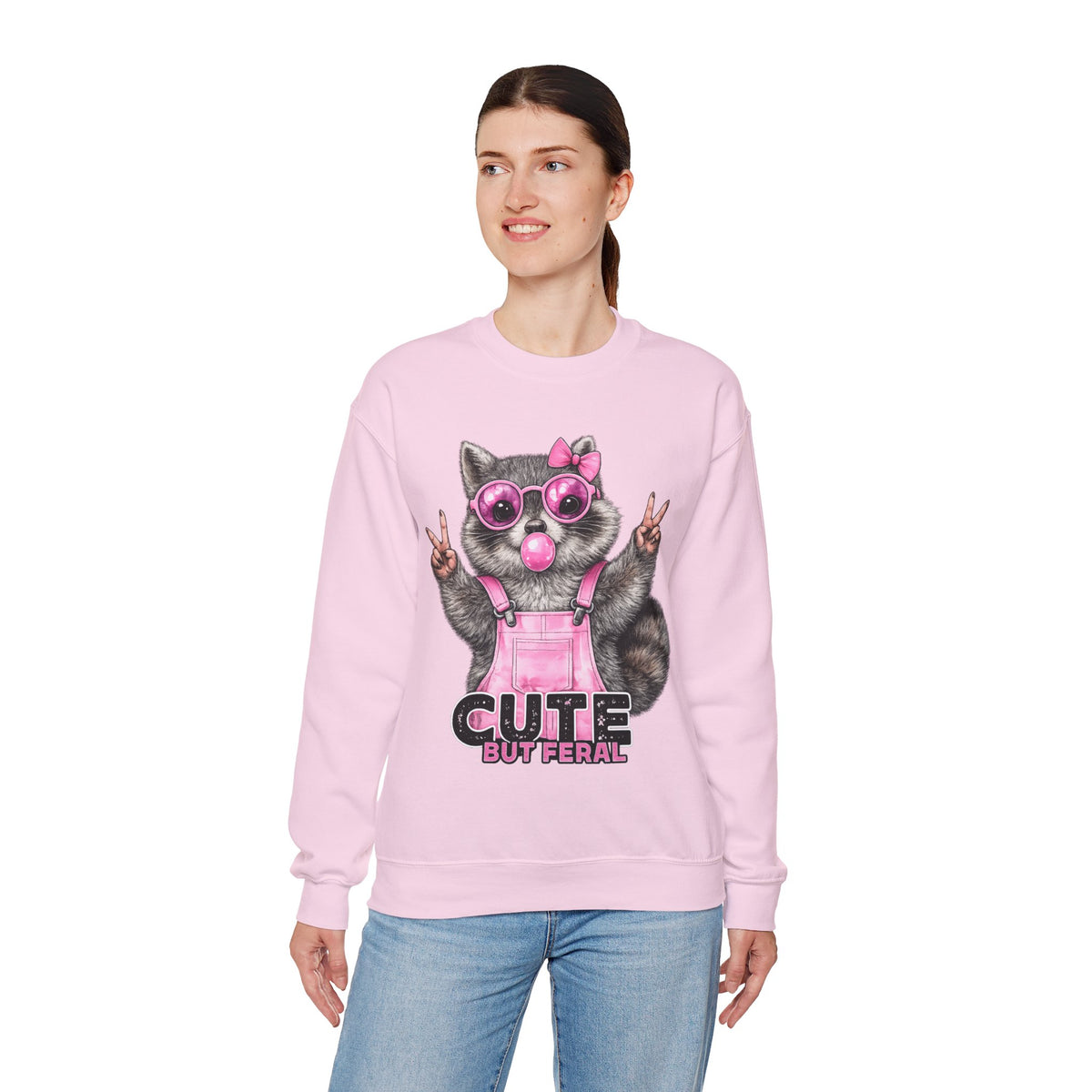 Cute But Feral, Raccoon in Pink Bibs – Gildan Heavy Blend | Trendy Women’s Soft Sweatshirt. Direct to Garment. Printed & Shipped in the USA. Unisex Sizes.