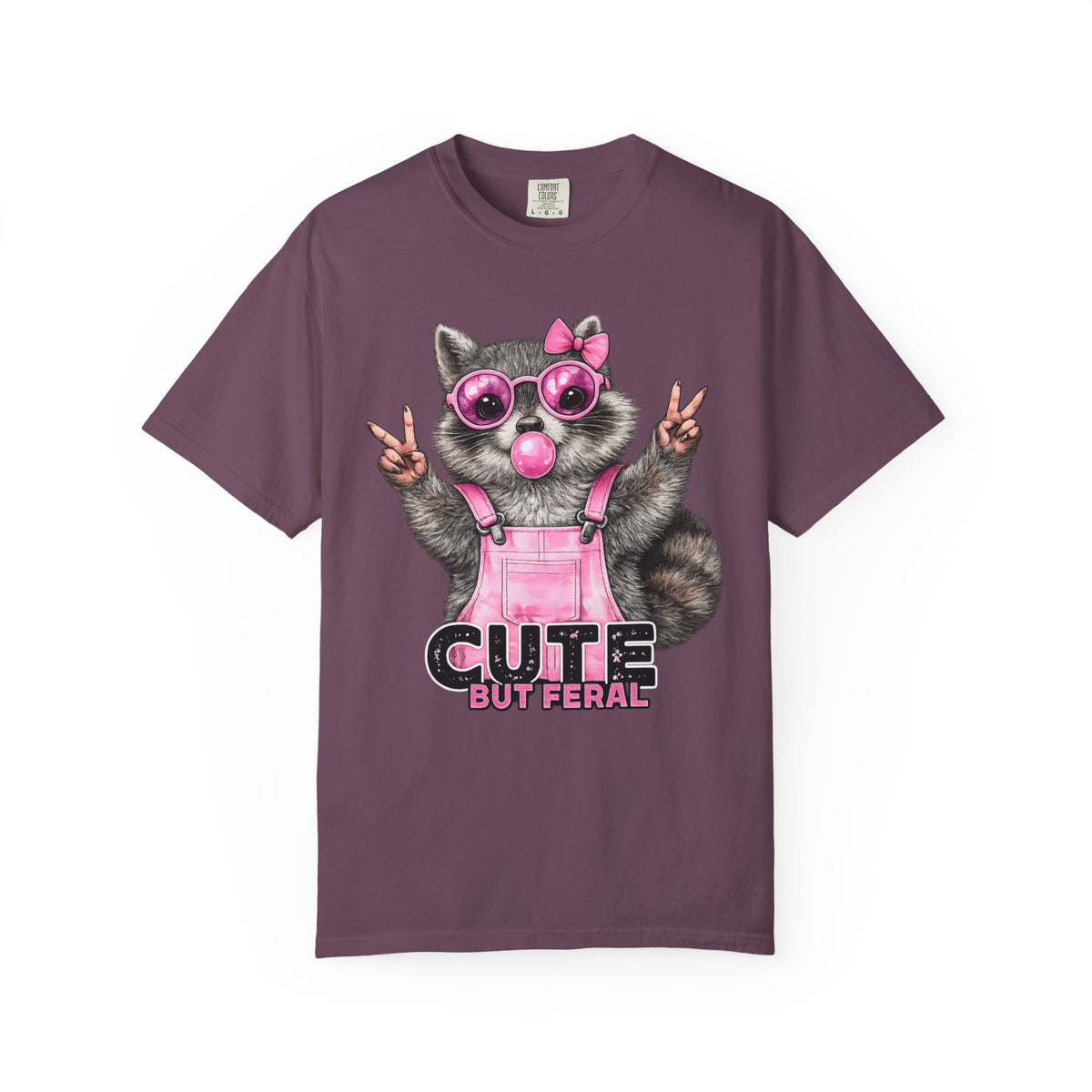 Cute But Feral, Raccoon in Pink Bibs - Comfort Colors | Trendy Women's T-Shirt. Direct to Garment. Printed & Shipped in the USA. Unisex Sizes.