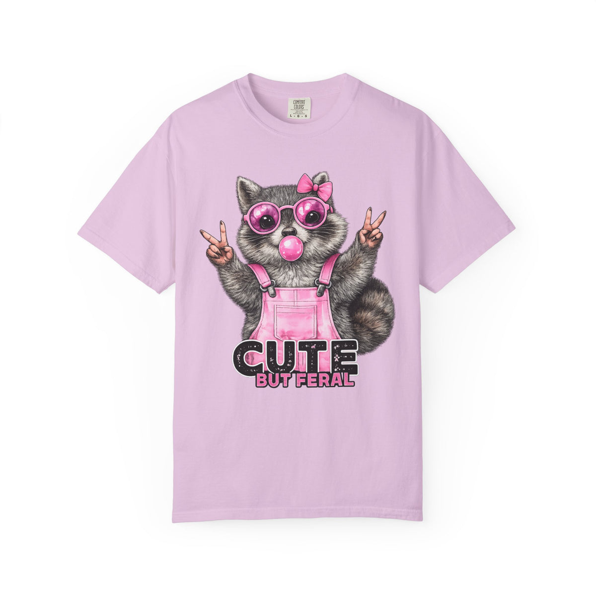 Cute But Feral, Raccoon in Pink Bibs - Comfort Colors | Trendy Women's T-Shirt. Direct to Garment. Printed & Shipped in the USA. Unisex Sizes.