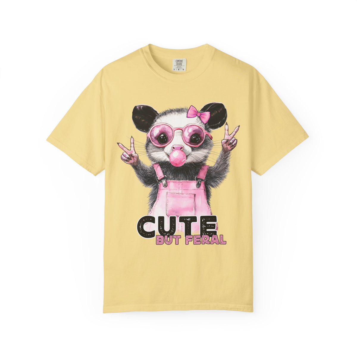 Cute But Feral, Possum in Pink Bibs - Comfort Colors | Trendy Women's T-Shirt. Direct to Garment. Printed & Shipped in the USA. Unisex Sizes.