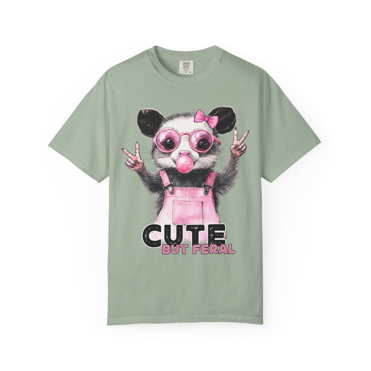 Cute But Feral, Possum in Pink Bibs - Comfort Colors | Trendy Women's T-Shirt. Direct to Garment. Printed & Shipped in the USA. Unisex Sizes.