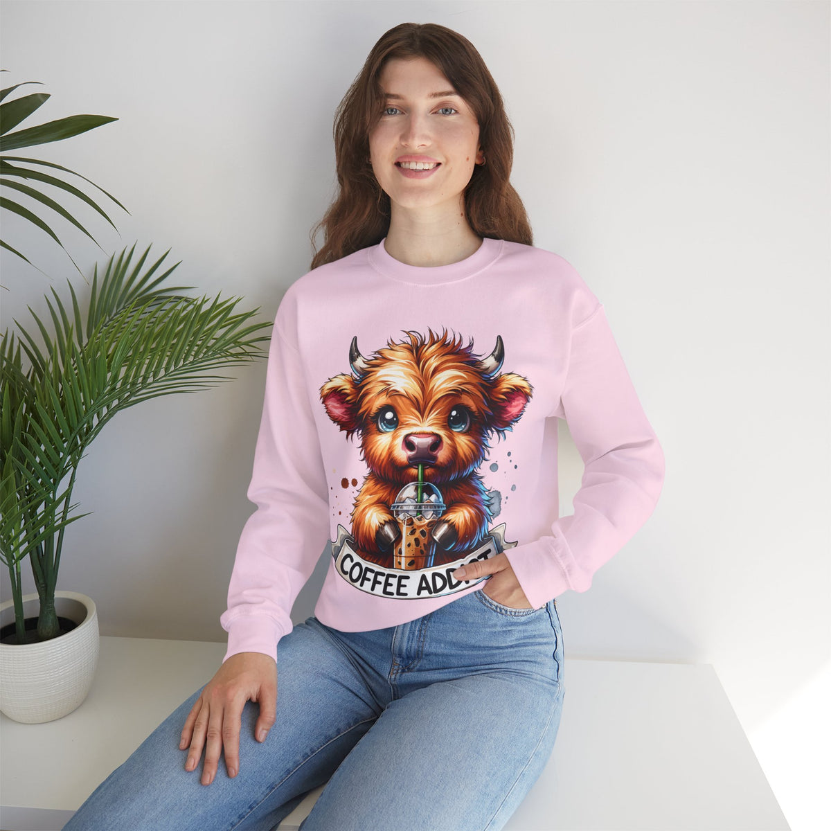 Coffee Addict Highland Cow Drinking Iced Coffee – Gildan Heavy Blend | Trendy Women’s Soft Sweatshirt. Direct to Garment. Printed & Shipped in the USA. Unisex Sizes.