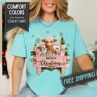 Highland Cow in Pink Truck Merry Christmas Holiday Farmhouse - Comfort Colors | Trendy Women's T-Shirt. Direct to Garment. Printed & Shipped in the USA. Unisex Sizes.