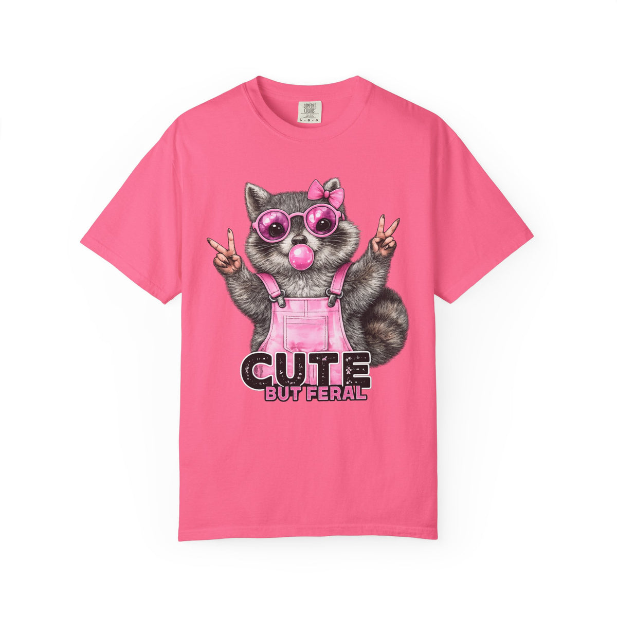 Cute But Feral, Raccoon in Pink Bibs - Comfort Colors | Trendy Women's T-Shirt. Direct to Garment. Printed & Shipped in the USA. Unisex Sizes.