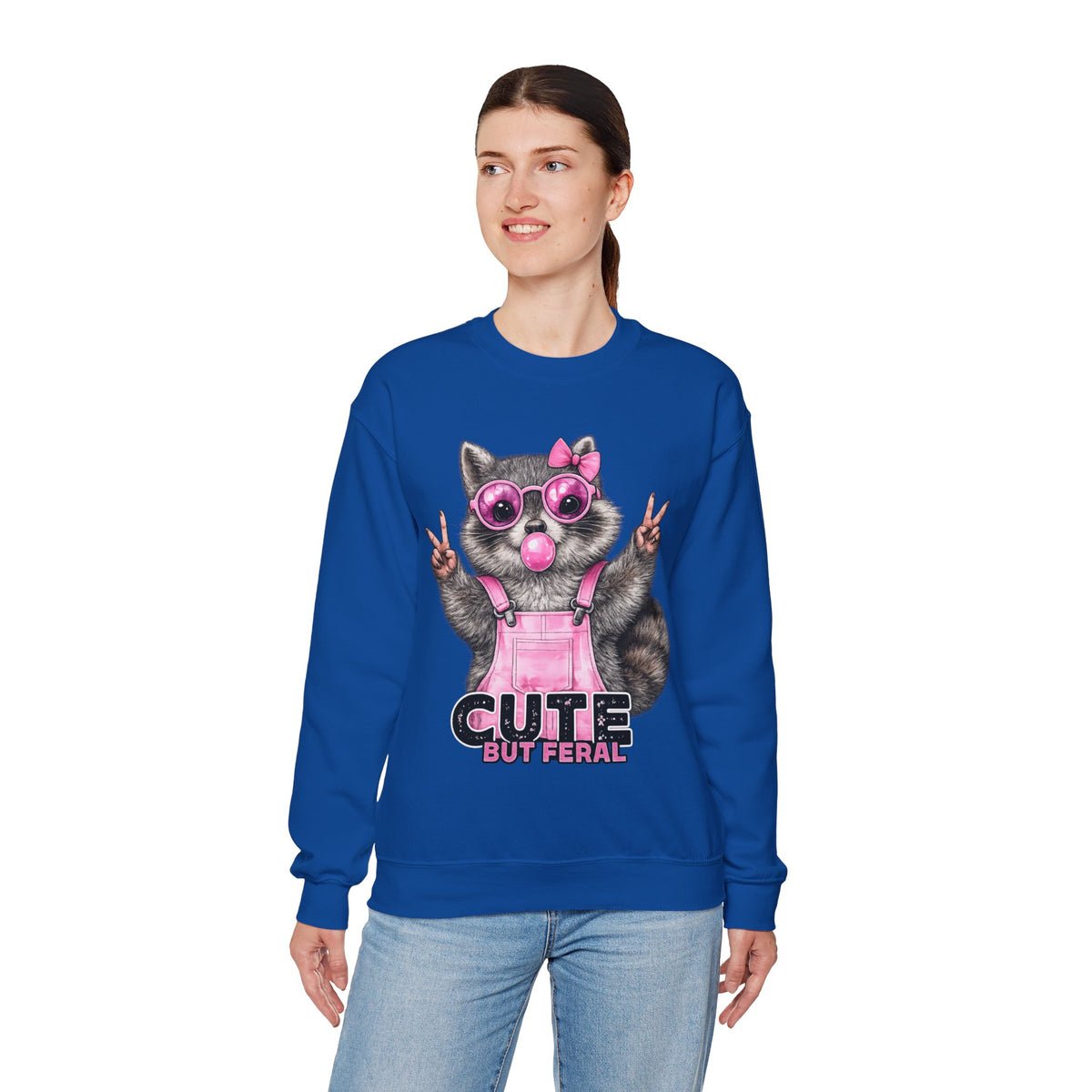 Cute But Feral, Raccoon in Pink Bibs – Gildan Heavy Blend | Trendy Women’s Soft Sweatshirt. Direct to Garment. Printed & Shipped in the USA. Unisex Sizes.