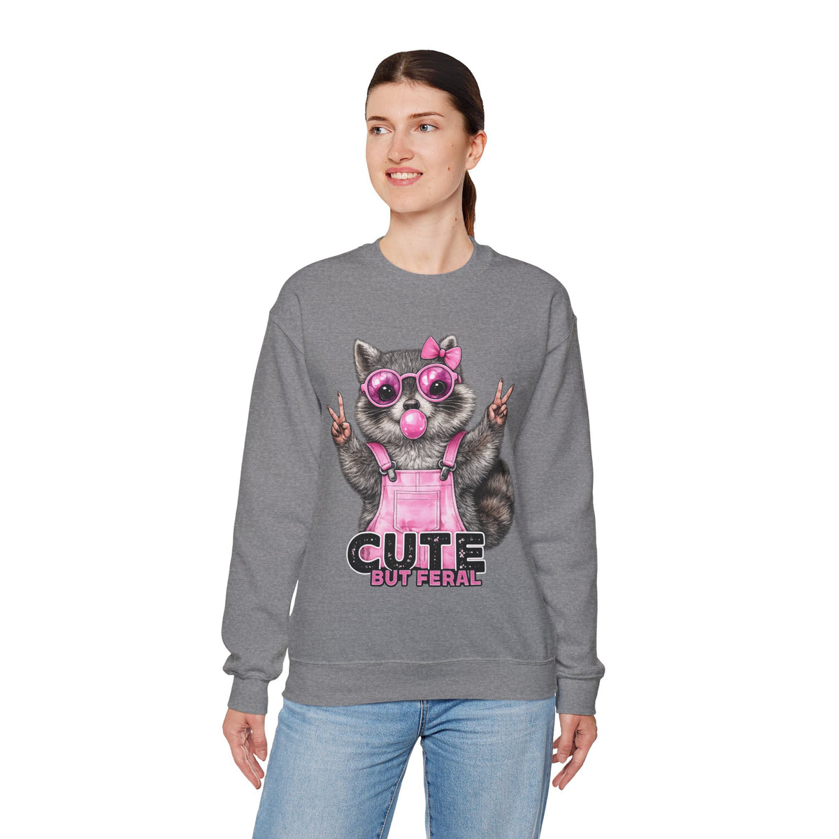 Cute But Feral, Raccoon in Pink Bibs – Gildan Heavy Blend | Trendy Women’s Soft Sweatshirt. Direct to Garment. Printed & Shipped in the USA. Unisex Sizes.