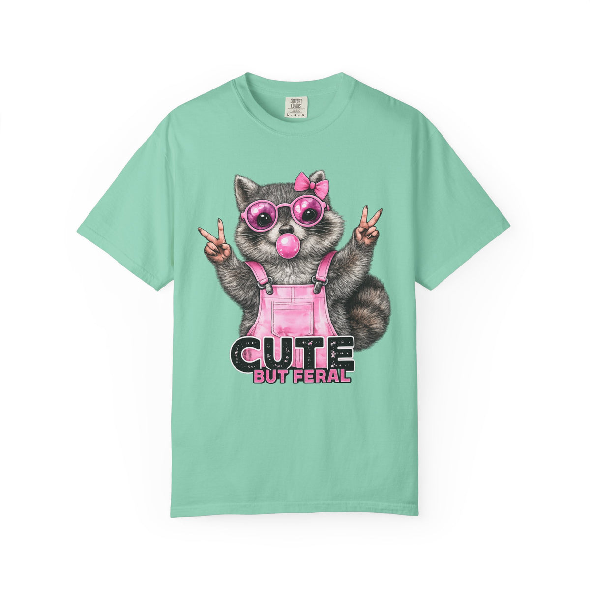Cute But Feral, Raccoon in Pink Bibs - Comfort Colors | Trendy Women's T-Shirt. Direct to Garment. Printed & Shipped in the USA. Unisex Sizes.