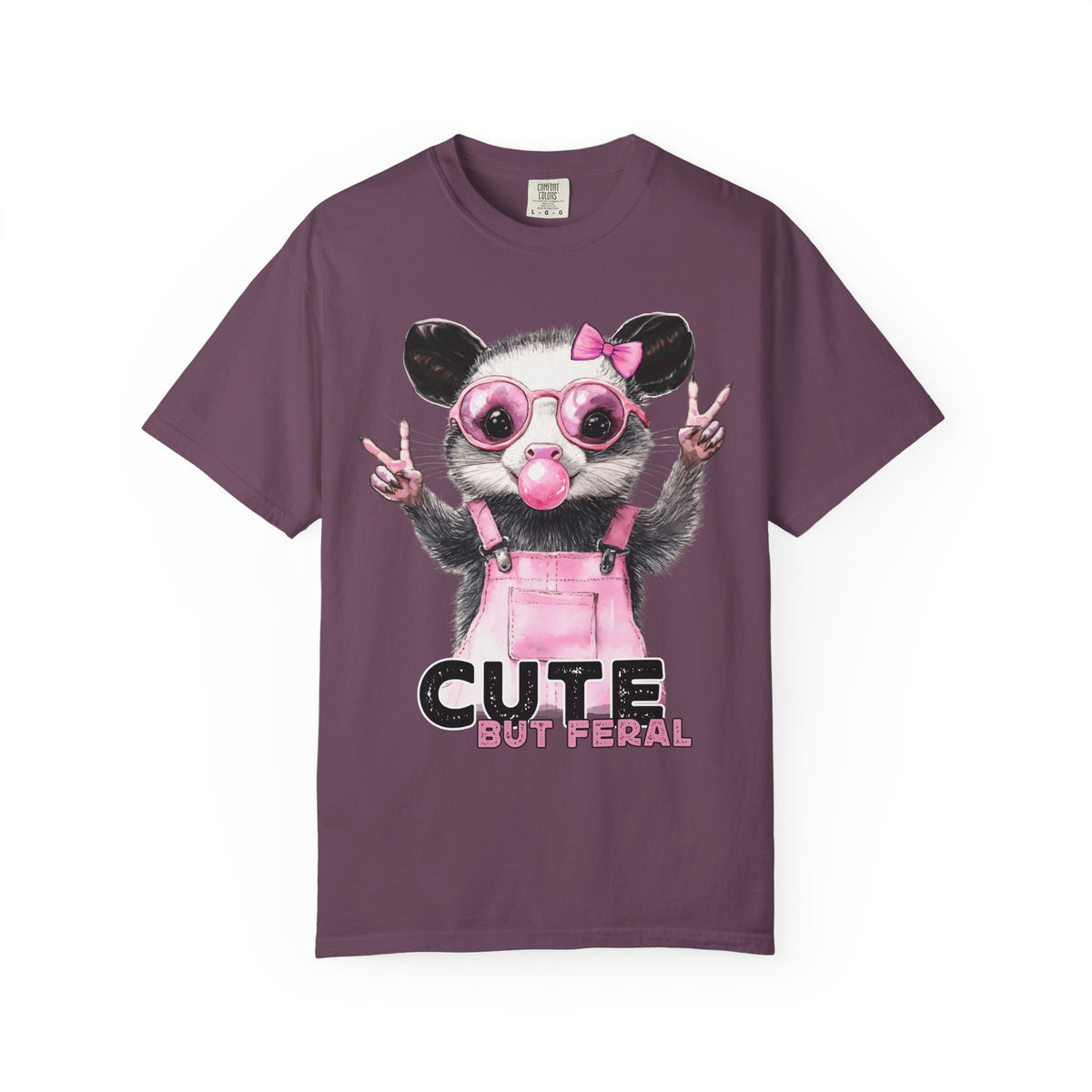 Cute But Feral, Possum in Pink Bibs - Comfort Colors | Trendy Women's T-Shirt. Direct to Garment. Printed & Shipped in the USA. Unisex Sizes.