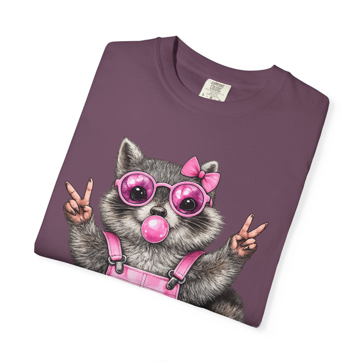 Cute But Feral, Raccoon in Pink Bibs - Comfort Colors | Trendy Women's T-Shirt. Direct to Garment. Printed & Shipped in the USA. Unisex Sizes.