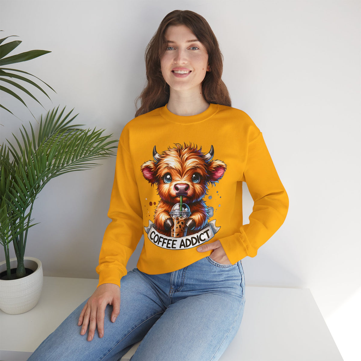 Coffee Addict Highland Cow Drinking Iced Coffee – Gildan Heavy Blend | Trendy Women’s Soft Sweatshirt. Direct to Garment. Printed & Shipped in the USA. Unisex Sizes.