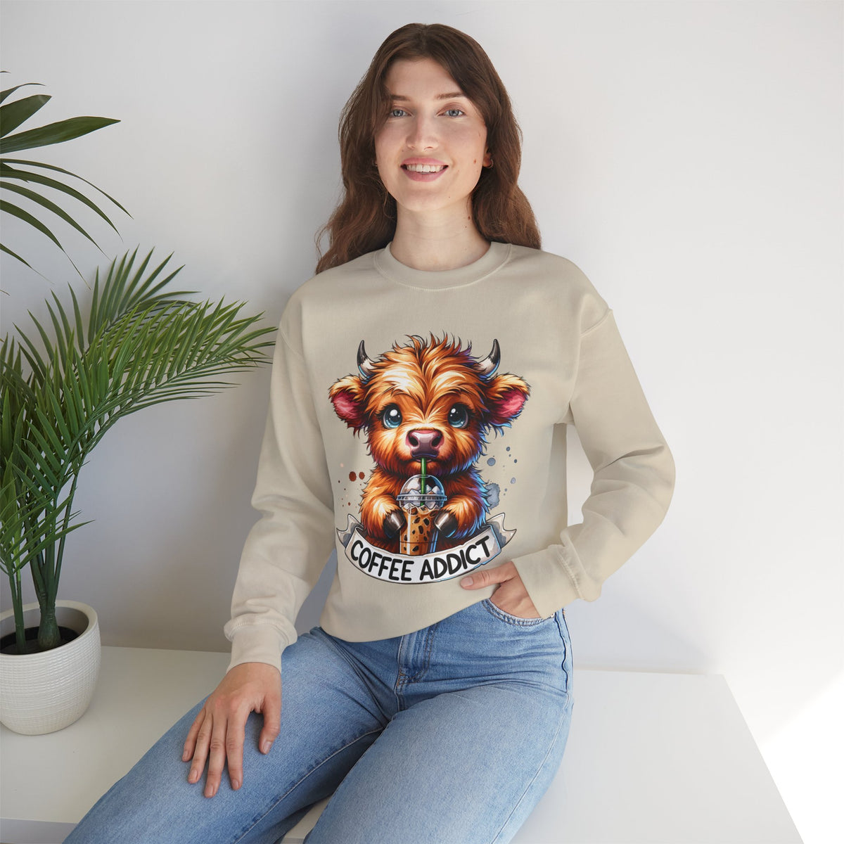 Coffee Addict Highland Cow Drinking Iced Coffee – Gildan Heavy Blend | Trendy Women’s Soft Sweatshirt. Direct to Garment. Printed & Shipped in the USA. Unisex Sizes.