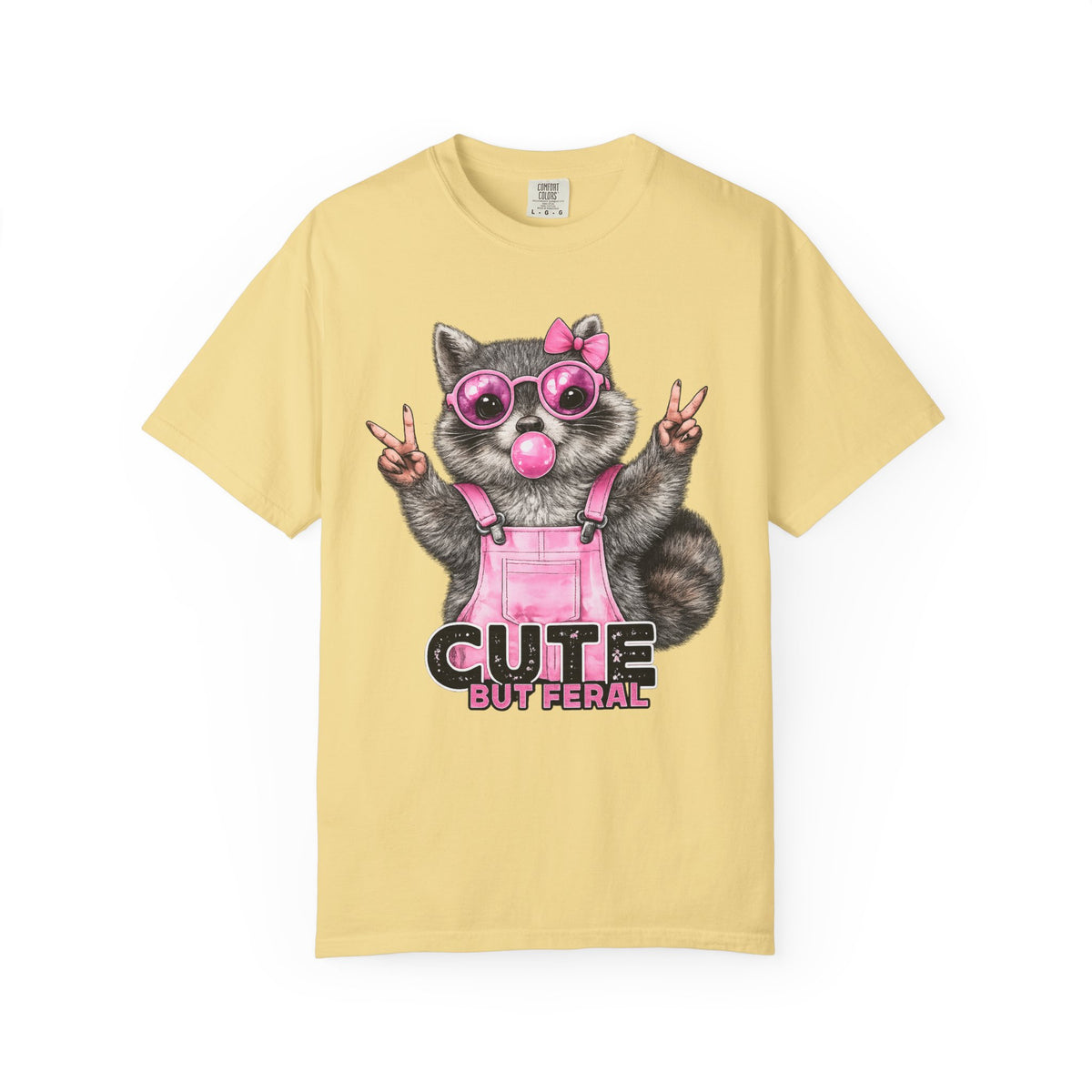 Cute But Feral, Raccoon in Pink Bibs - Comfort Colors | Trendy Women's T-Shirt. Direct to Garment. Printed & Shipped in the USA. Unisex Sizes.