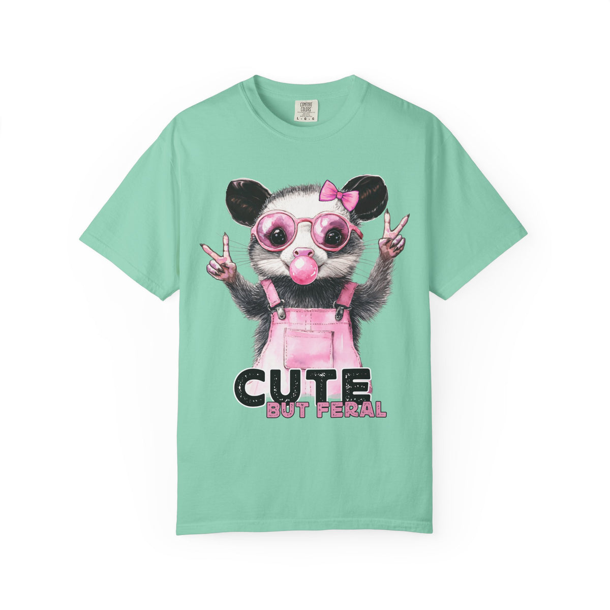 Cute But Feral, Possum in Pink Bibs - Comfort Colors | Trendy Women's T-Shirt. Direct to Garment. Printed & Shipped in the USA. Unisex Sizes.