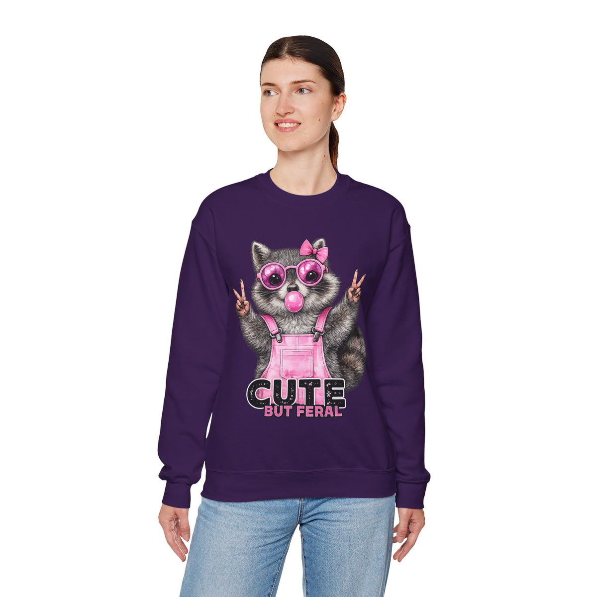 Cute But Feral, Raccoon in Pink Bibs – Gildan Heavy Blend | Trendy Women’s Soft Sweatshirt. Direct to Garment. Printed & Shipped in the USA. Unisex Sizes.