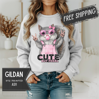 Cute But Feral, Squirrel in Pink Bibs – Gildan Heavy Blend | Trendy Women’s Soft Sweatshirt. Direct to Garment. Printed & Shipped in the USA. Unisex Sizes.
